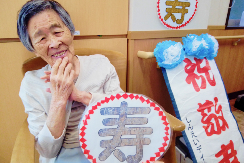 写真：寿祝い中の高齢女性